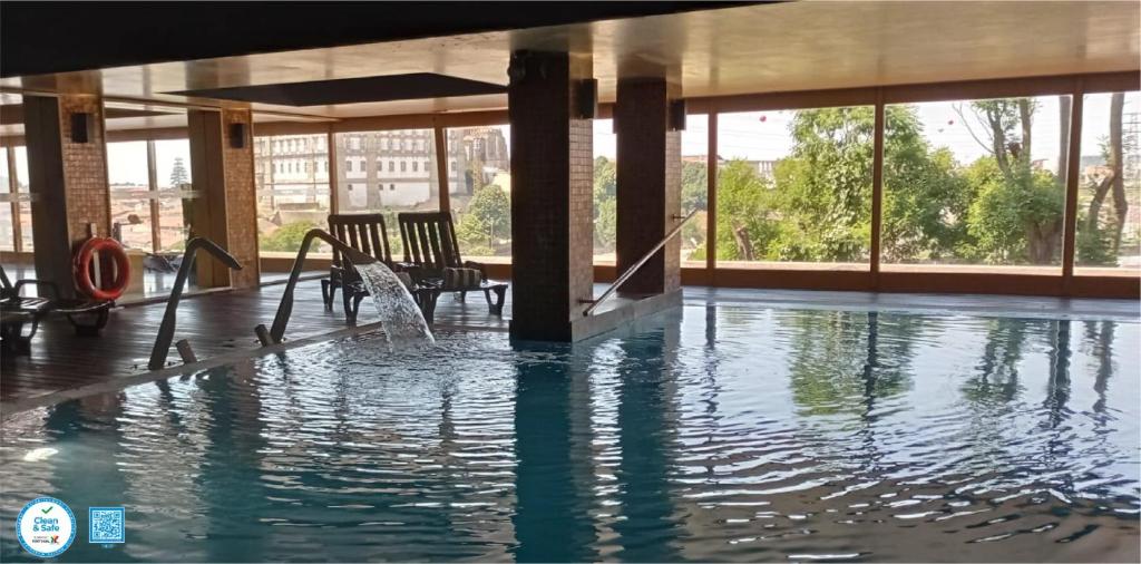 uma piscina com água num edifício em Santana Hotel & SPA em Vila do Conde