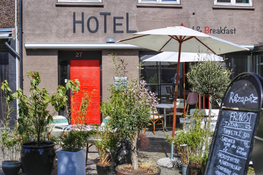 un hotel con una puerta roja y una sombrilla en Hotel Sniva, en Rønne