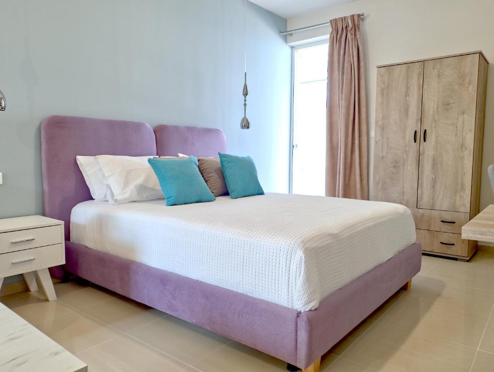 a bedroom with a bed with a purple headboard at Epipleon Luxury Suites -104- Δωμάτιο 35τμ με βεράντα 35τμ μπροστά στη θάλασσα in Nafpaktos