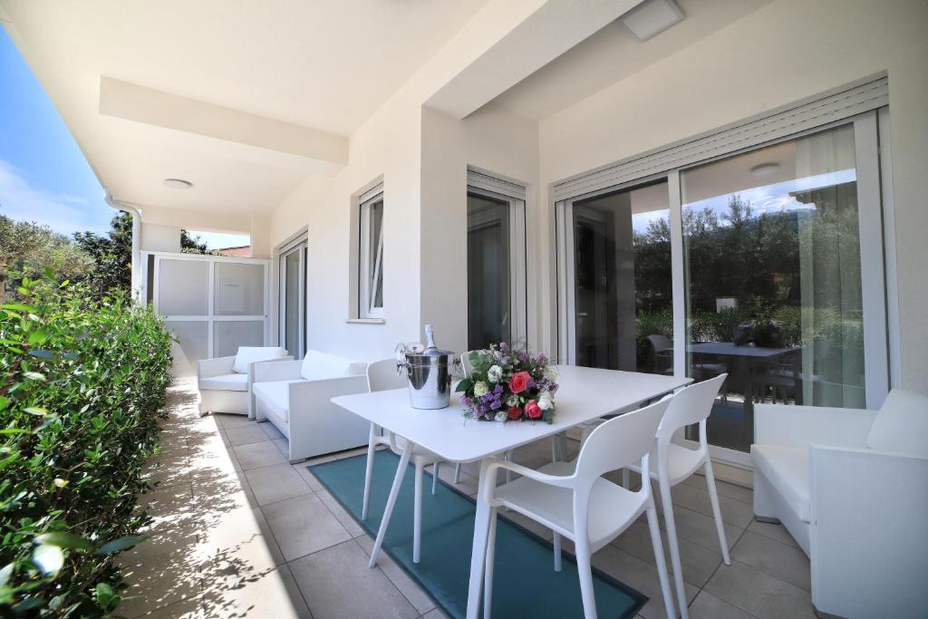 patio z białym stołem i białymi krzesłami w obiekcie Capo Zen - Apartments & SPA w mieście Capo dʼOrlando