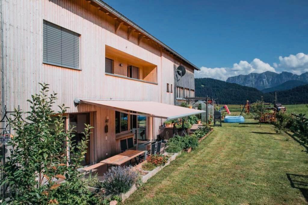 un edificio con un banco frente a un patio en Rosenhaus 3, en Schwarzenberg im Bregenzerwald