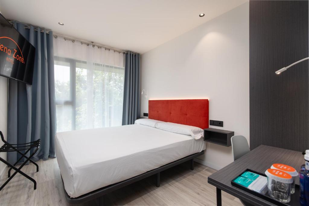 a bedroom with a large bed and a table at Arena Zone Hotel in Valencia