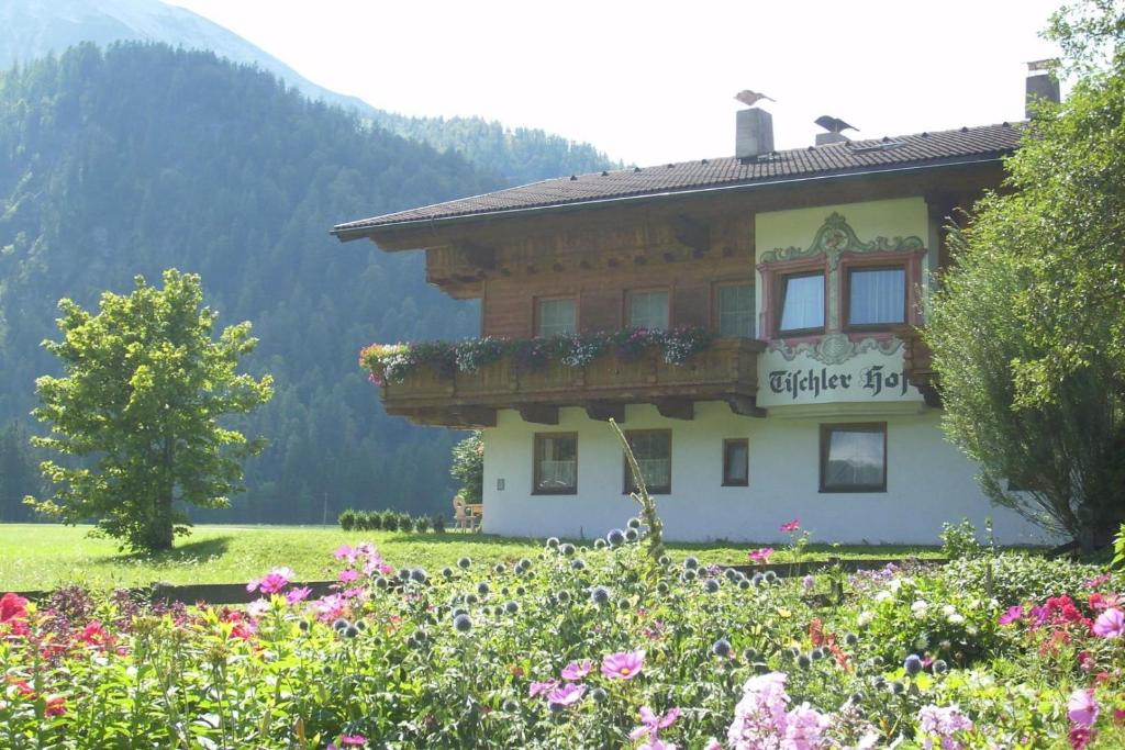 ein Gebäude auf einem Feld mit Blumen davor in der Unterkunft Tischlerhof in Achensee