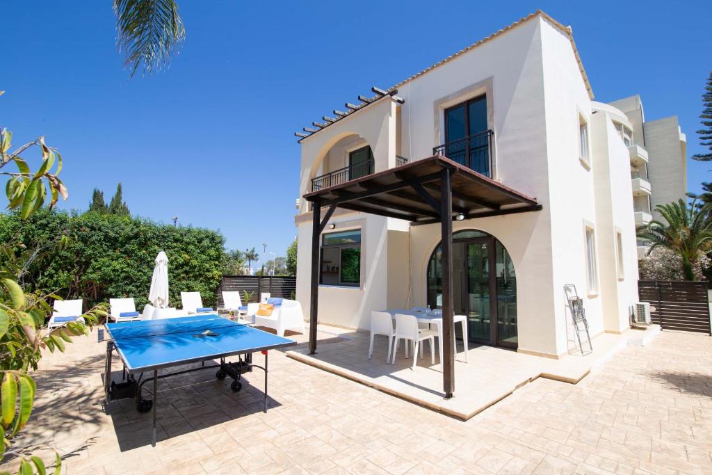 a patio with a table and chairs and a house at Mylos 9 in Protaras