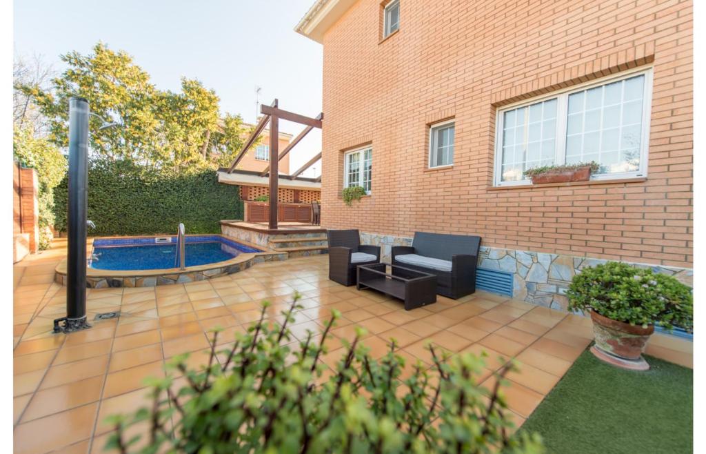 a patio with two chairs and a swimming pool at HomeHolidaysRentals Royal in Pineda de Mar