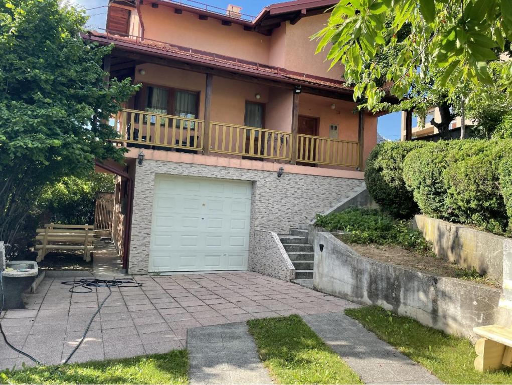 uma casa com uma porta de garagem e uma varanda em House Tuscany em Saraievo