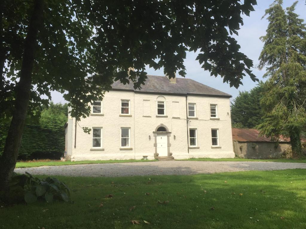 ein großes weißes Haus mit großer Auffahrt in der Unterkunft Ballyrider House Beautiful Triple Suite in Inch Cross Roads