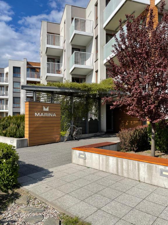 a building with a wooden gate in a courtyard at T&AMarina in Kąty Rybackie