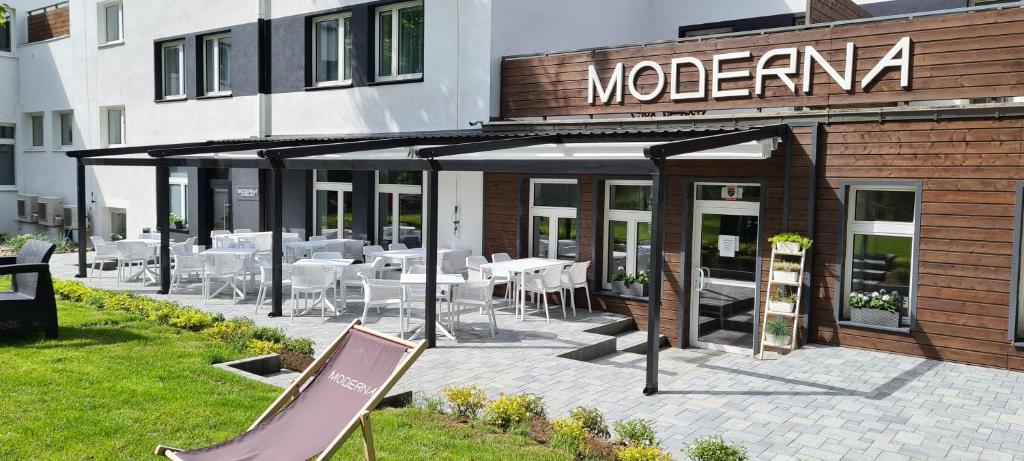 a restaurant with tables and chairs outside of a building at Resort Moderna Jastrzębia Góra in Jastrzębia Góra