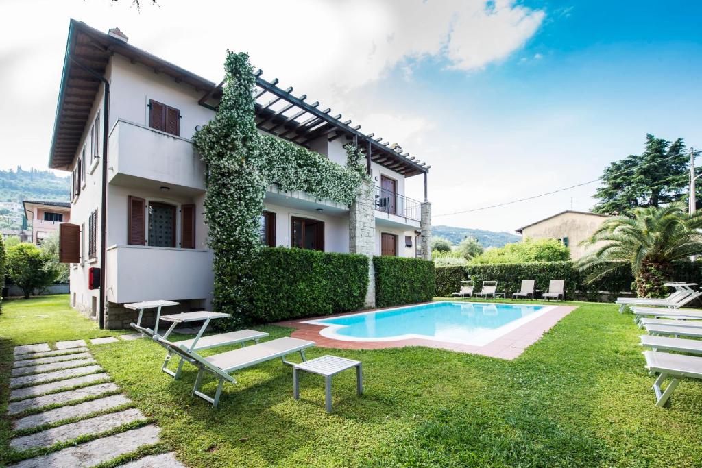 a villa with a swimming pool and a house at Appartamenti Meridiana in Torri del Benaco