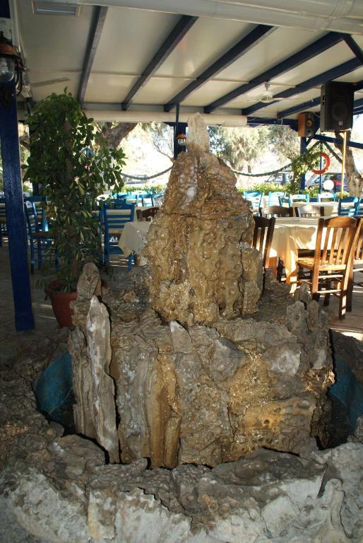 a large rock formation in front of a restaurant at Galazio Limani - Rooms to let in Moúdhros