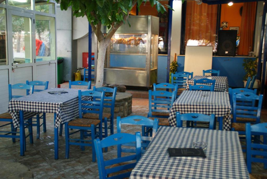 a restaurant with blue tables and blue chairs at Galazio Limani - Rooms to let in Moúdhros