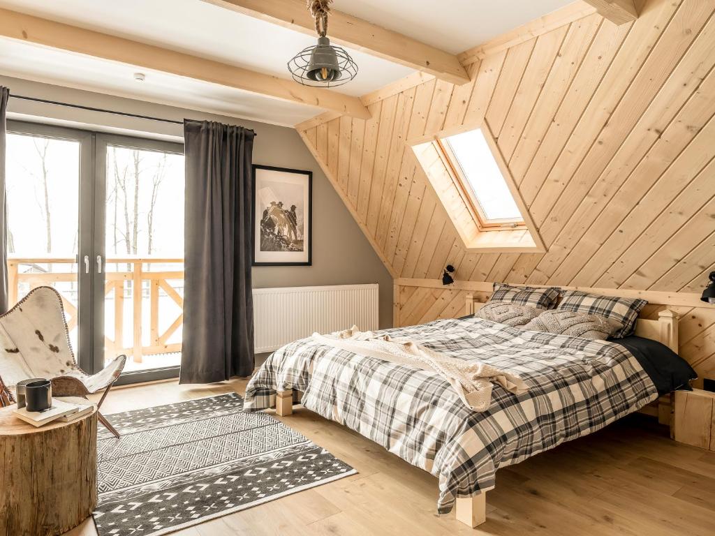 Ziębowe Domki في شوشولو: غرفة نوم بسرير وسقف خشبي
