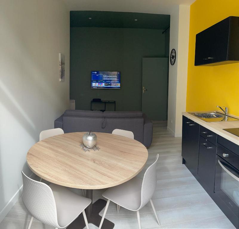 a table and chairs in a kitchen with a couch at Bel Appartement 40 M2 sans linge de lit et de toilette in Vals-les-Bains
