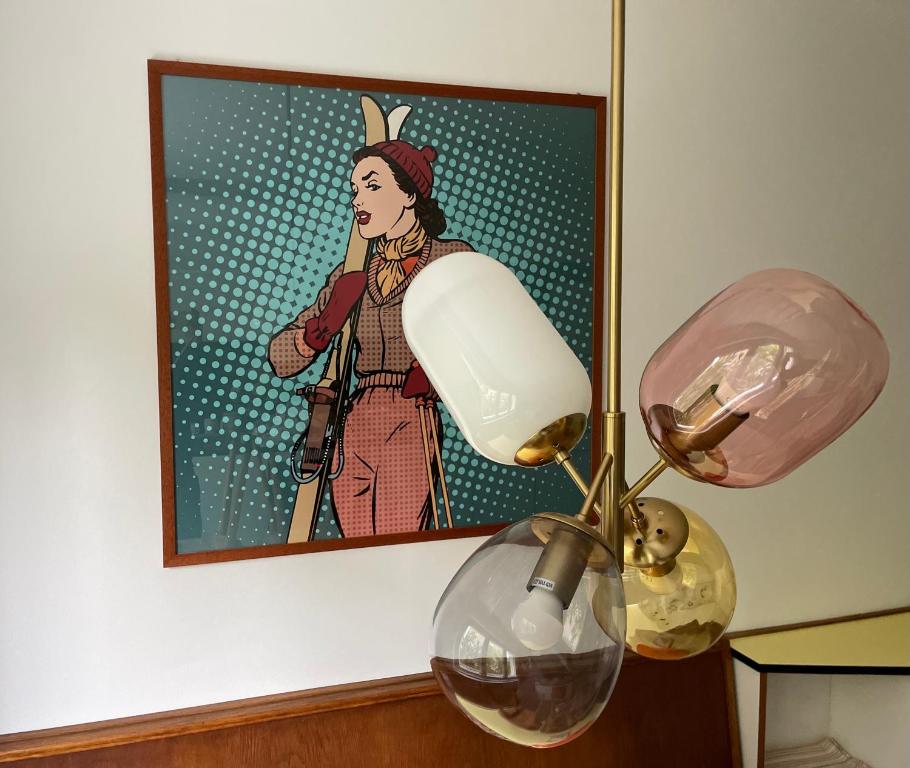 une lampe avec une photo d'une femme sur le mur dans l'établissement Villa Maria Dolomites Vintage Home, à Brunico