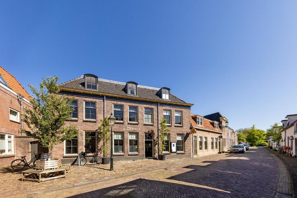a large brick building on a cobblestone street at Broeck Oudewater in Oudewater