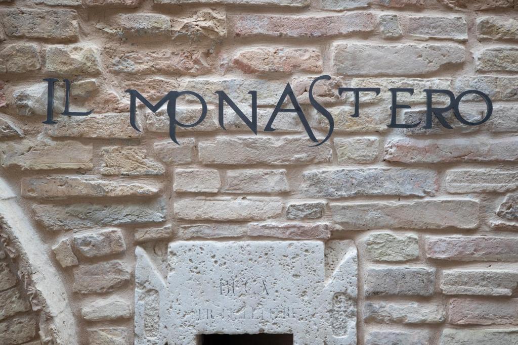 un panneau sur le côté d'un mur de briques dans l'établissement IL MONASTERO, à Monteprandone