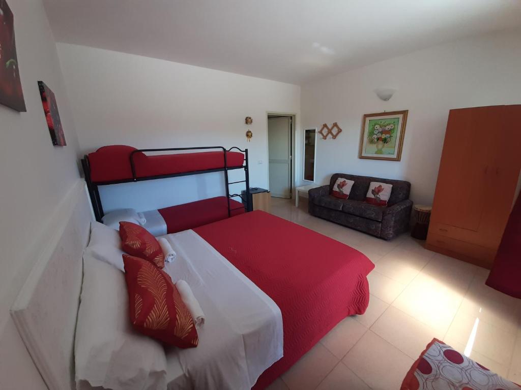 ペスキチにあるOsteria B&B Il Rifugioのベッドルーム(赤と白のベッド1台、ソファ付)
