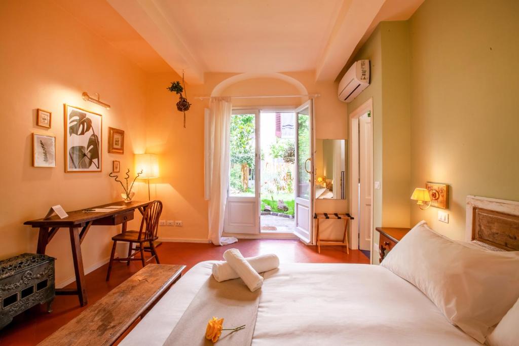 a bedroom with a bed and a desk and a window at Secret Garden Firenze B&B in Florence