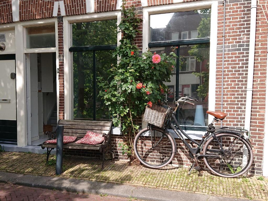 a bike parked in front of a house with a bench at Bed in de binnenstad ♡ bed downtown in Leeuwarden