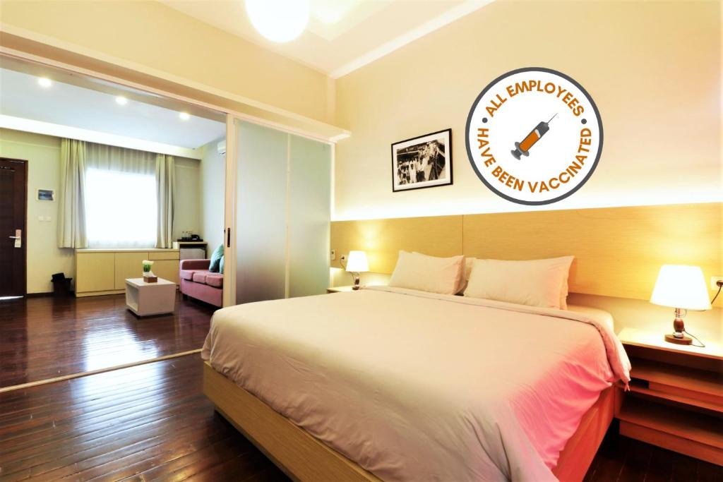 Habitación de hotel con cama y reloj en la pared en Pejaten Valley Residence, en Yakarta