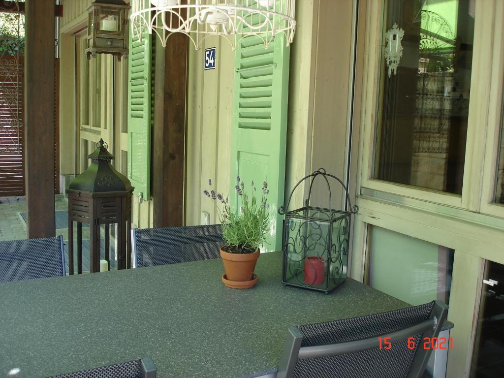 uma mesa com um vaso de plantas sentado num alpendre em Leimernhof em Thörishaus