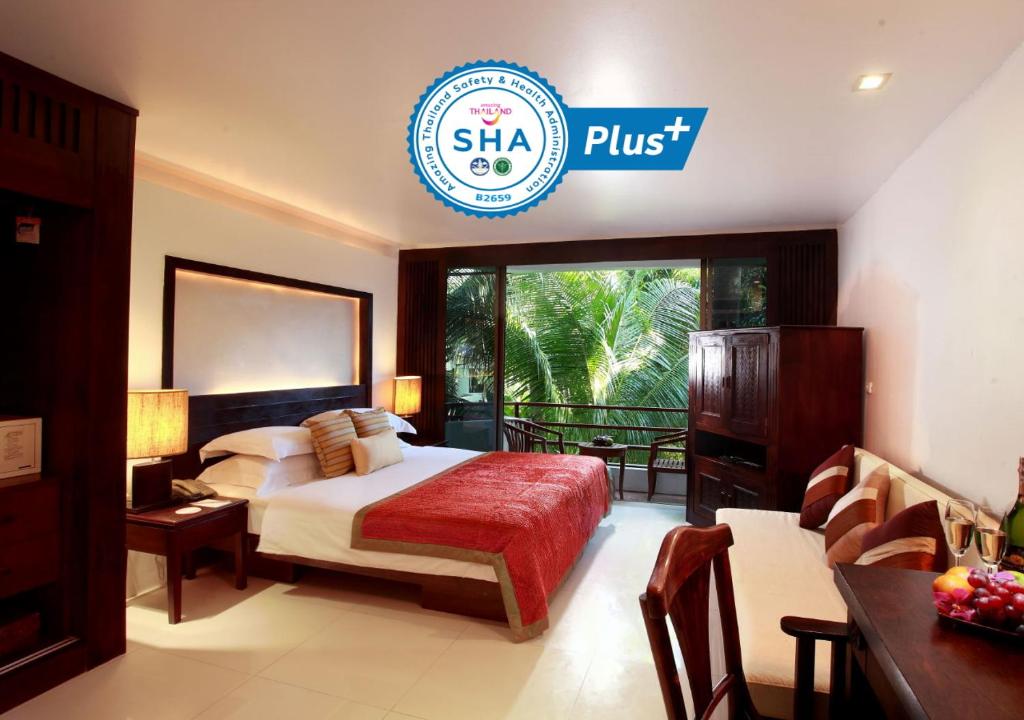 a hotel room with a bed and a sign that reads shea plus at Safari Beach Hotel - SHA Extra Plus in Patong Beach