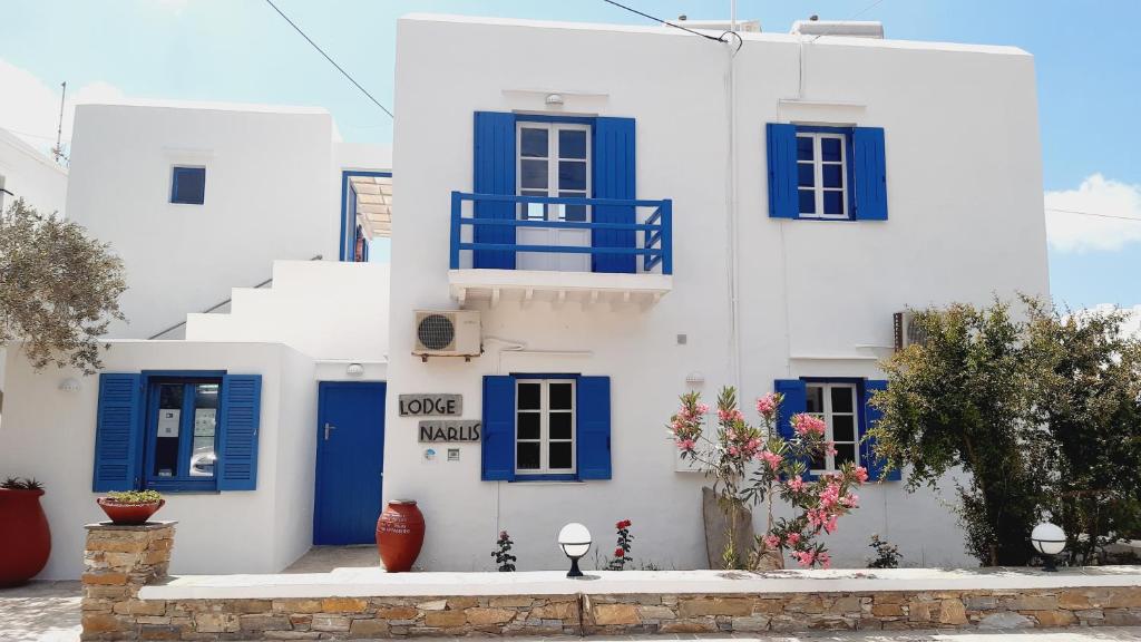 - un bâtiment blanc avec des portes et des fenêtres bleues dans l'établissement Lodge Narlis, à Platis Gialos