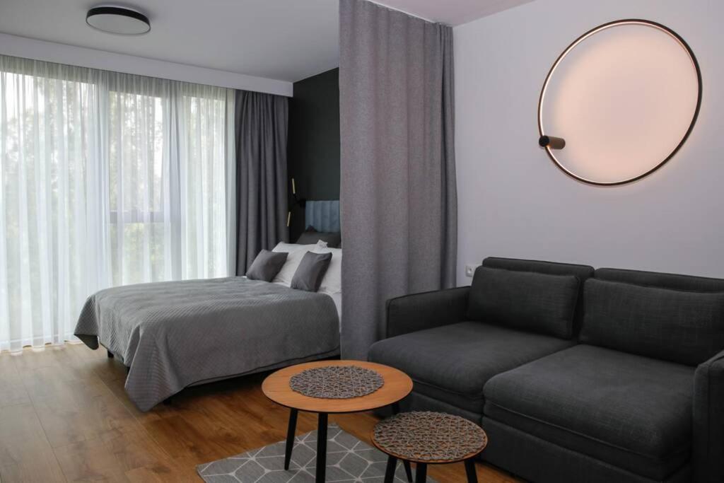 een woonkamer met een bank, een bed en een spiegel bij Apartament 4th Floor in Lublin