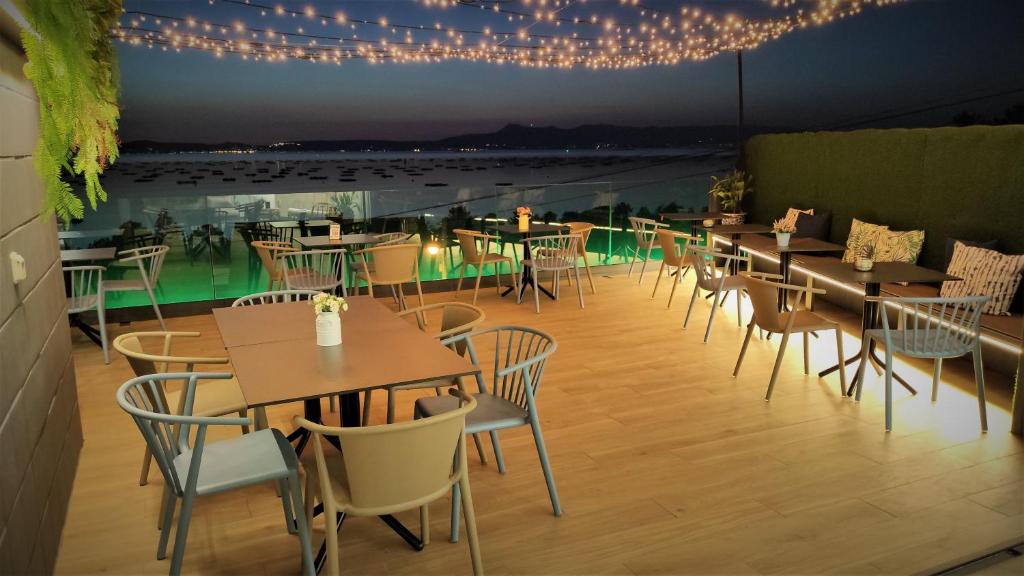 un restaurante con mesas, sillas y luces en Hotel Mirador Ría de Arosa, en Reboredo