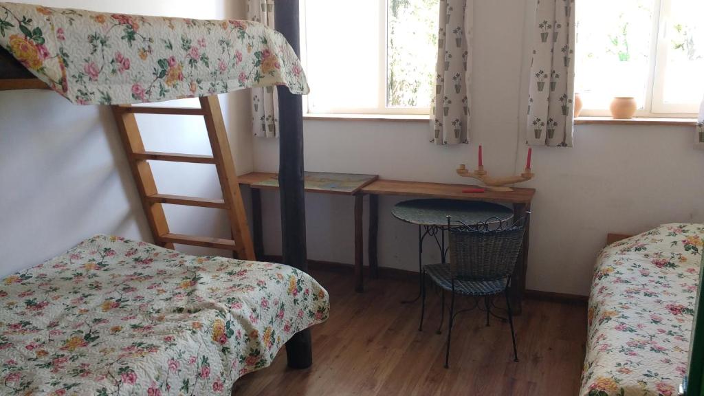 a bedroom with a bunk bed and a desk and a table at Kernaveland in Kernavė