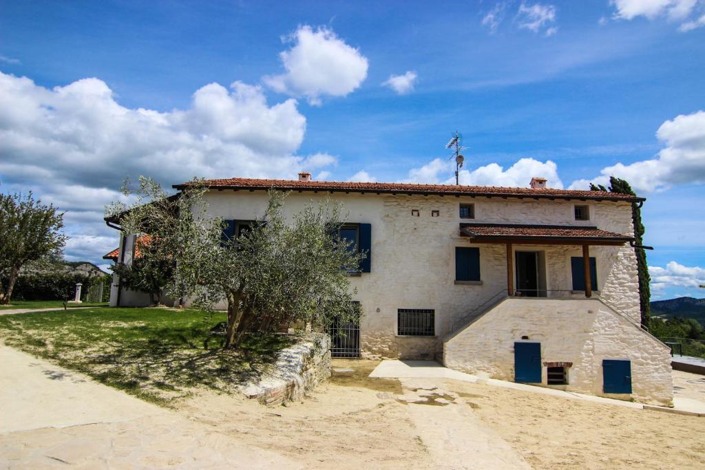 stary kamienny dom z drzewem przed nim w obiekcie Relais Mevigo - Casa Padronale w mieście Casola Valsenio