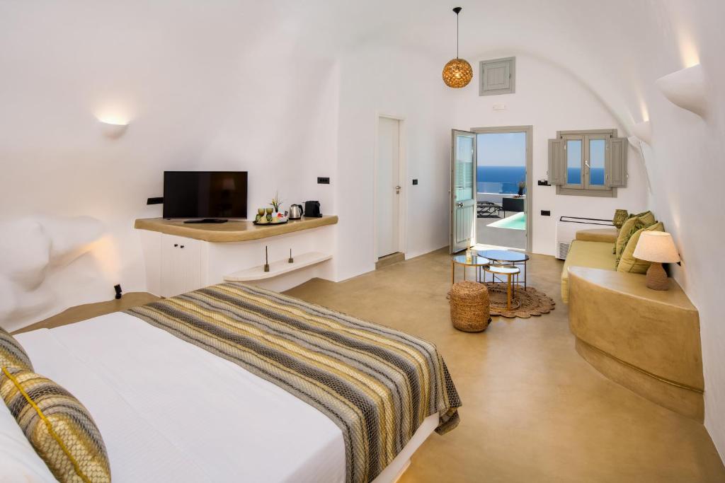 sypialnia z łóżkiem, kanapą i telewizorem w obiekcie Siete Mares Luxury Suites w Imerovíglion