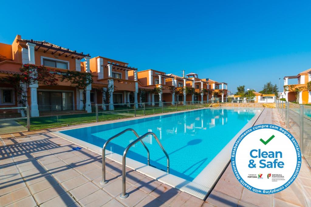 una piscina frente a algunos edificios de apartamentos en Orange Lux Villa, en Luz de Tavira