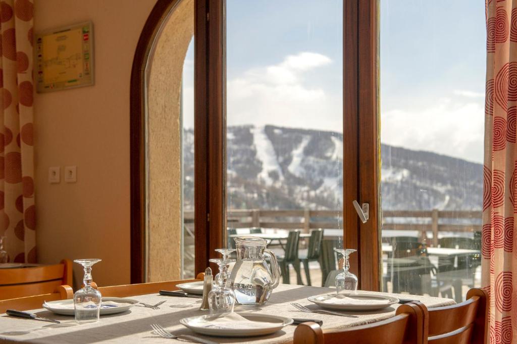 een tafel in een restaurant met uitzicht op een berg bij VTF Les Esquirousses in Arvieux