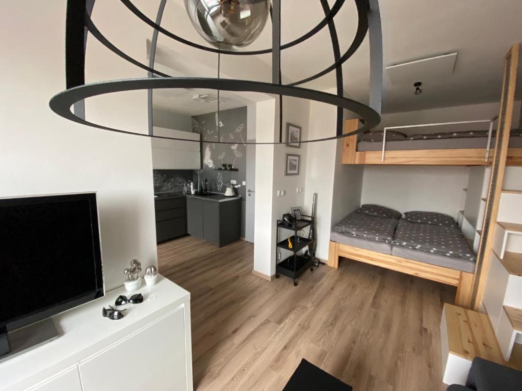 ein Wohnzimmer mit einem Bett und einem großen Kronleuchter in der Unterkunft Apartmán Domenica 404 in Mikulov