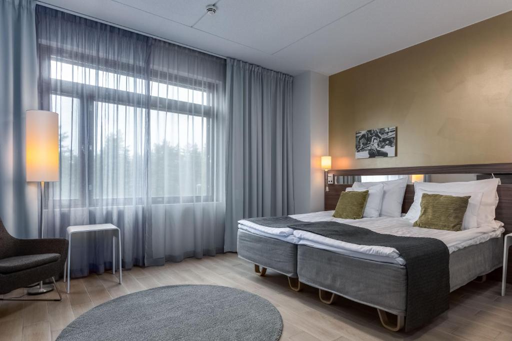 1 dormitorio con cama y ventana grande en Holiday Club Vierumäki en Vierumäki