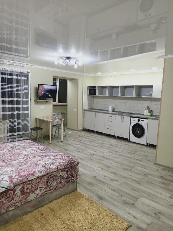 ApartNew in City Centr في أوست - كامينوغورسك: غرفة كبيرة بها سرير ومطبخ