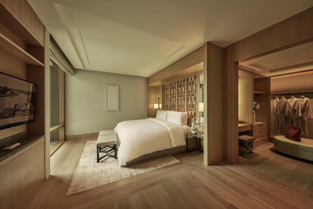 A warm wood-accented guest room with a neatly made bed and a walk-in wardrobe.