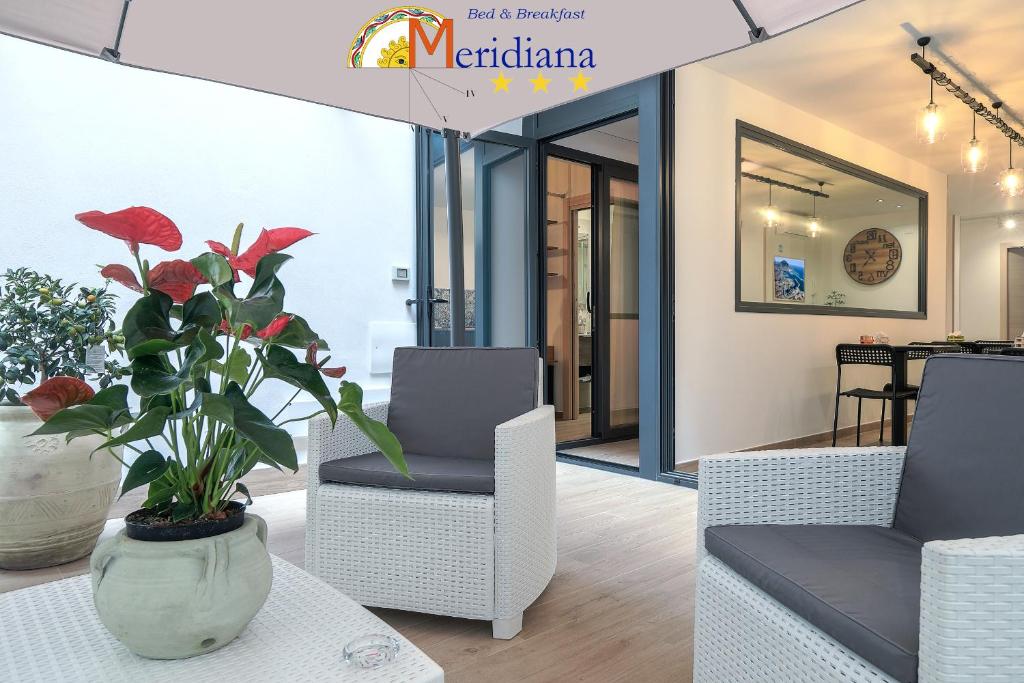 a living room with two chairs and a vase with a plant at Meridiana B&B in Palermo