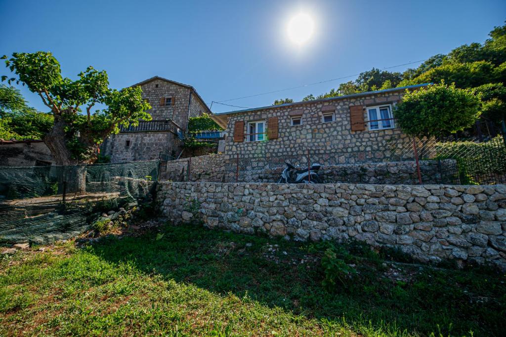 a stone wall in front of a house at Ethno house OSOBAK in Virpazar