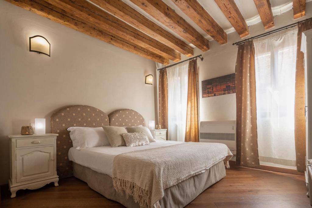 a bedroom with a bed and a large window at Corte Contarina San Marco Apartment R&R in Venice