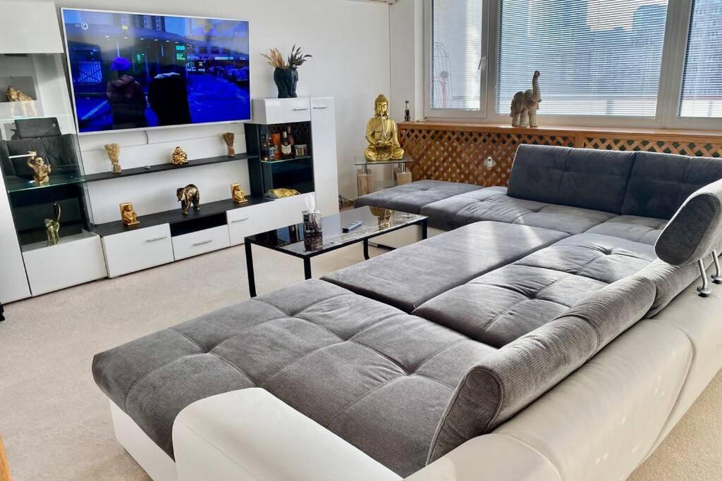 uma sala de estar com um sofá grande e uma televisão em Luxusný zmodernizovaný Apartmán v centre Košíc em Košice