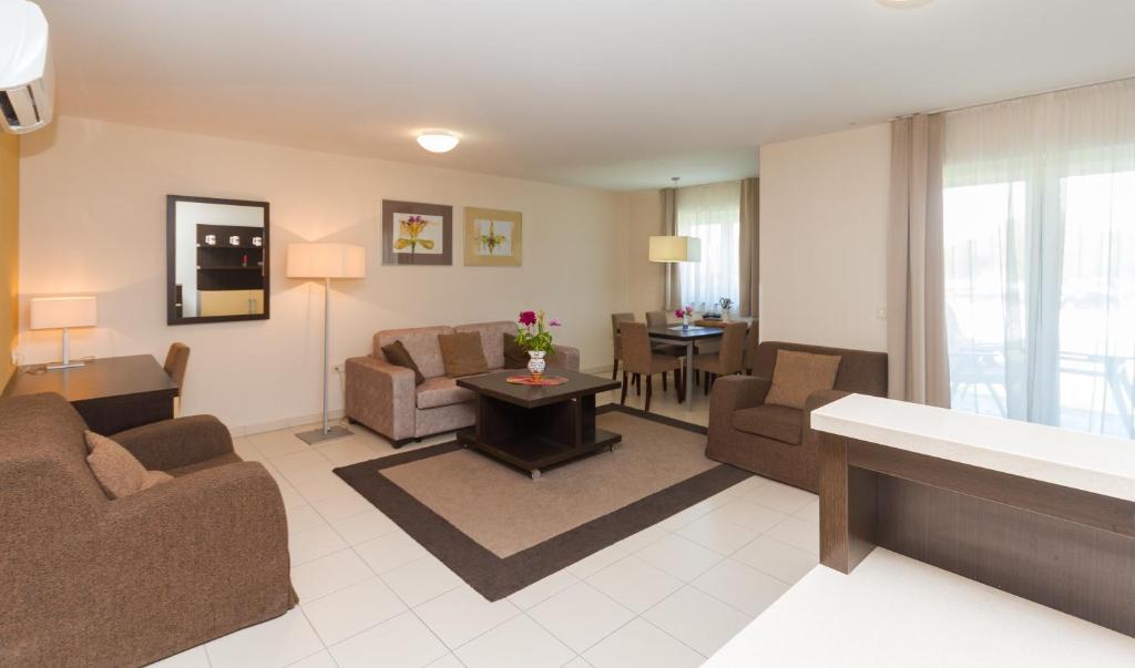 Una sala de estar con sofás y sillas y una mesa. en Levant 200 in Marina Portoroz by Locap Group, en Portorož