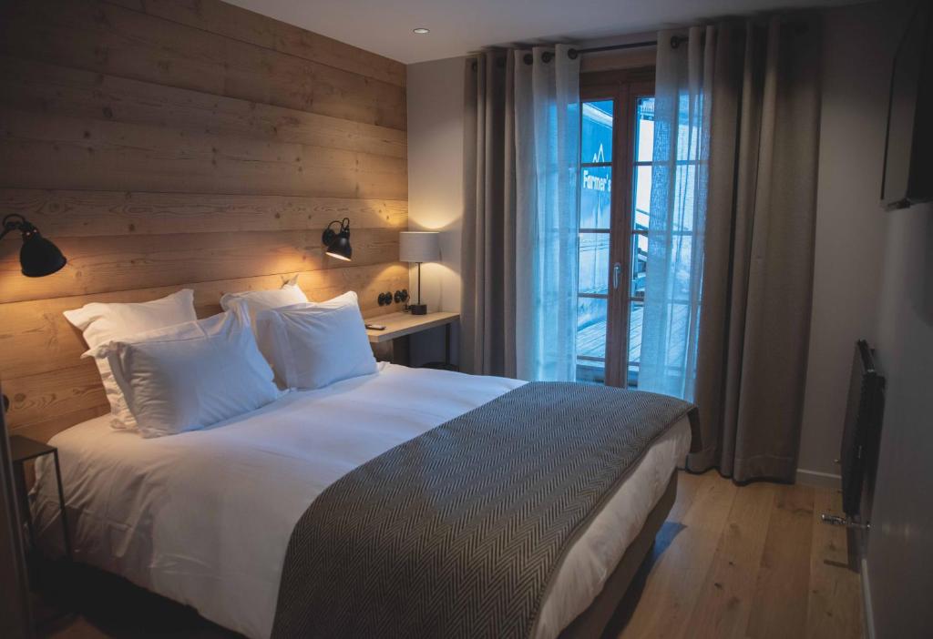 a bedroom with a large bed with a wooden wall at La Ferme in La Clusaz