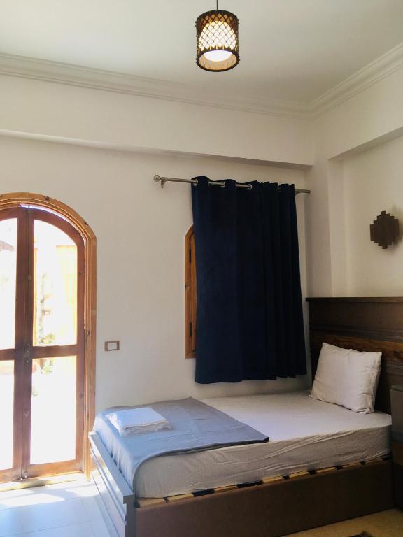 a bedroom with a bed and a window with a curtain at Villa 22 in Dahab