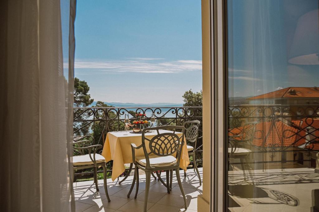 una mesa y sillas en un balcón con vistas en Amadria Park Hotel Agava en Opatija