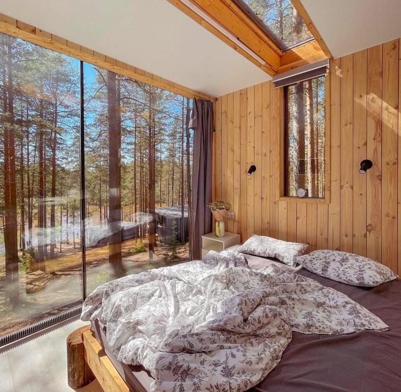 a bedroom with a bed and a large window at Greenvald Park Scandinavia in Ogon'ki