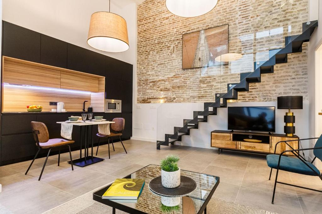 un soggiorno con TV e scala di Amplísimo y coqueto apartamento de diseño en pleno centro a Siviglia