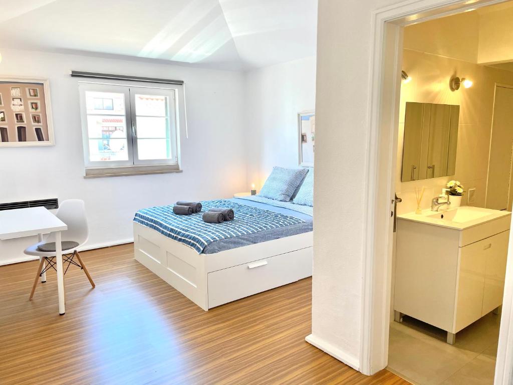 カスカイスにあるCascais Terrace Bay Apartmentのベッドルーム1室(ベッド1台、シンク、デスク付)